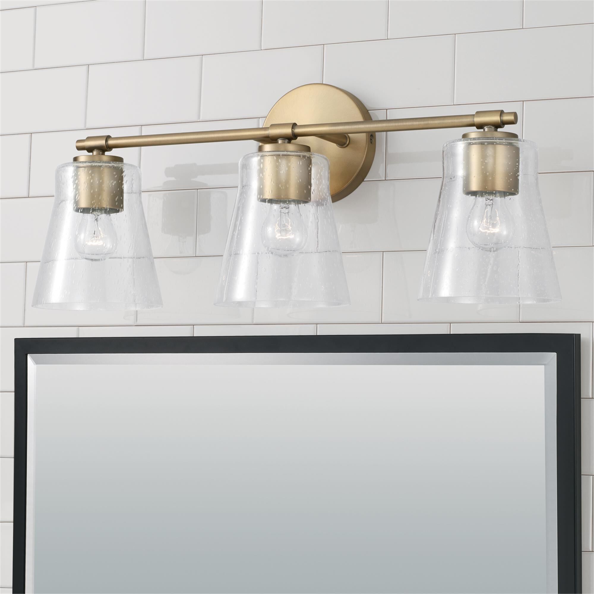 Shown in Aged Brass finish and Clear Seeded glass