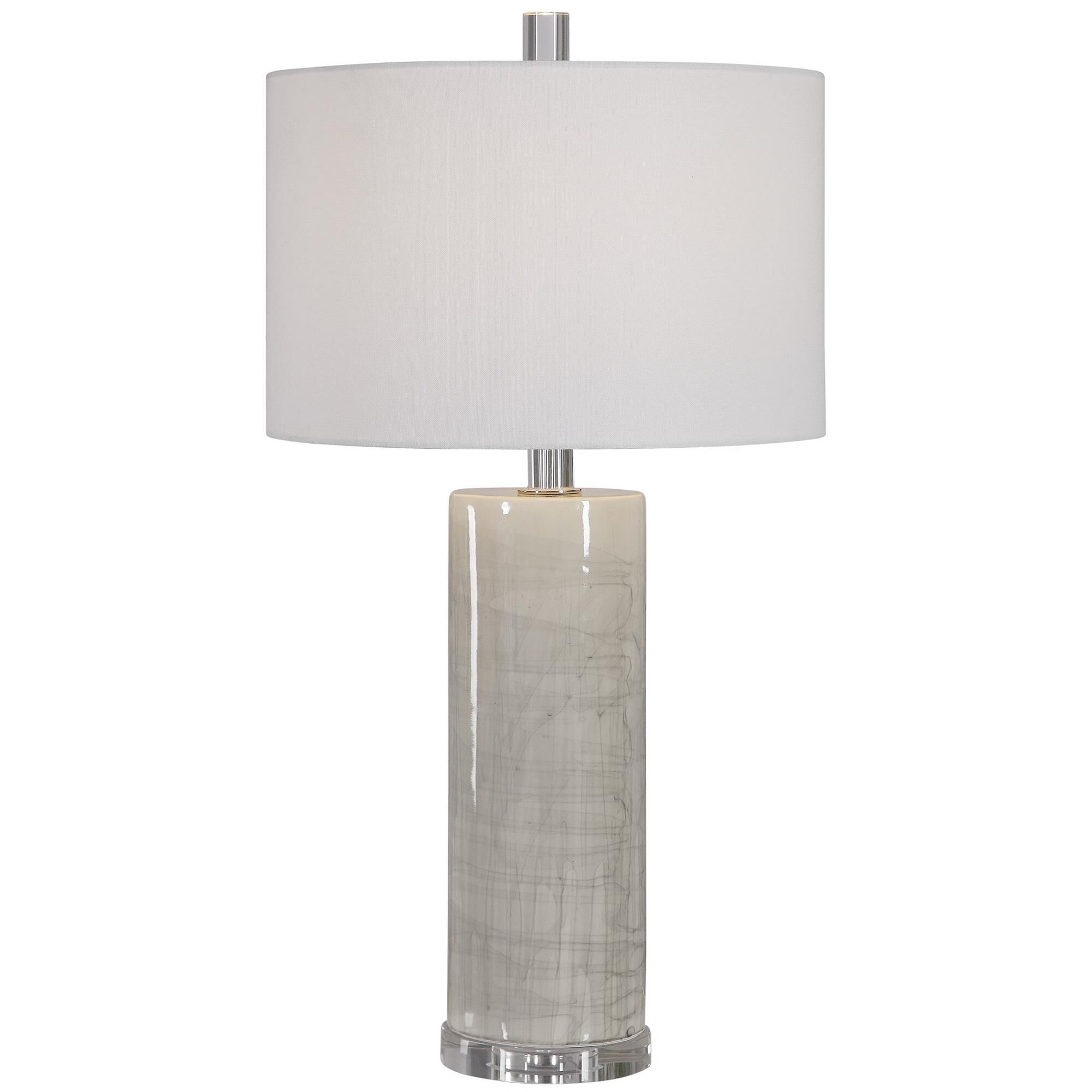 Shown in Modern In Design, This Ceramic Table Lamp Showcases A Neutral Beige Glaze With An Abstract Gray Drip finish and Round Hardback  With Linning Background shade