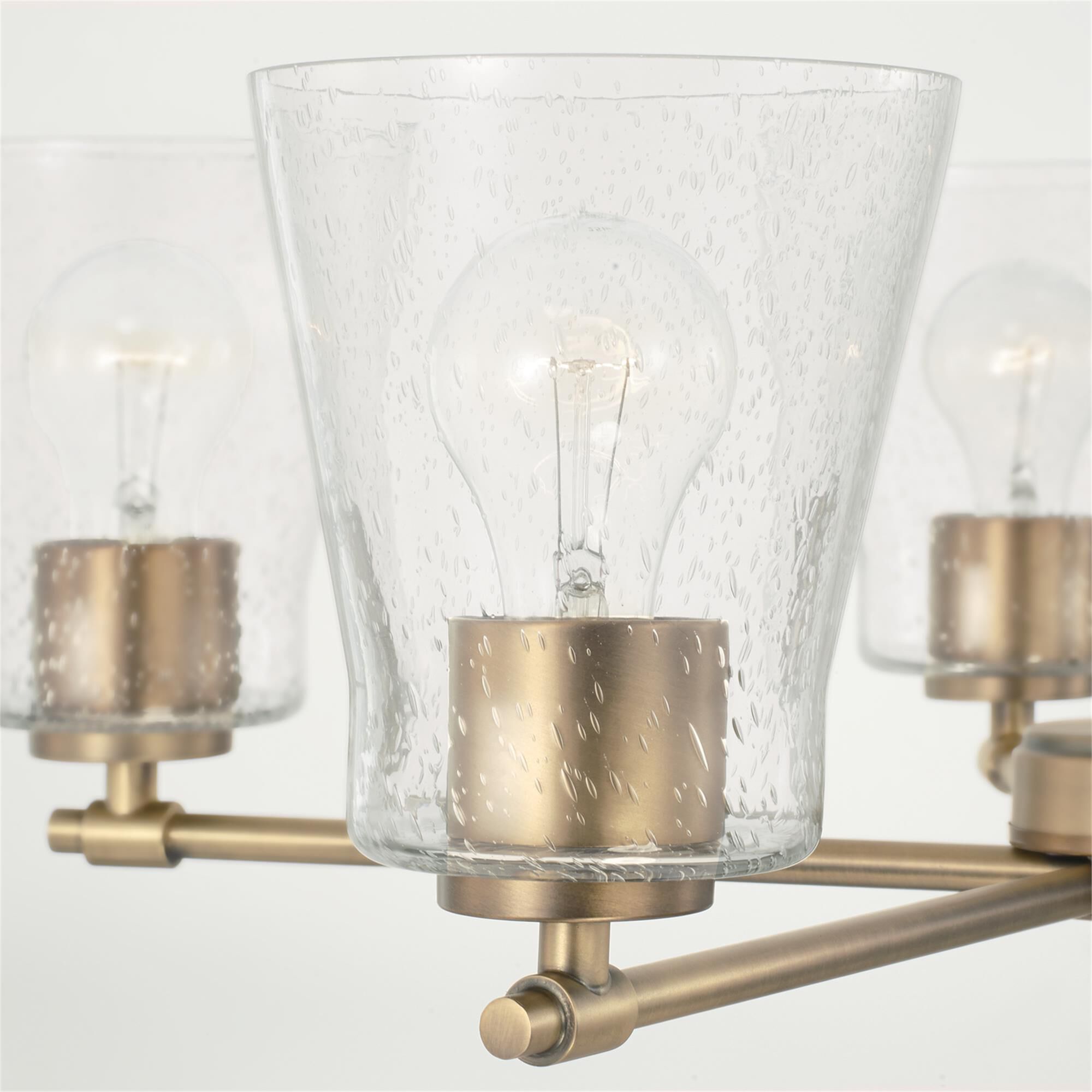 Shown in Aged Brass finish and Clear Seeded glass