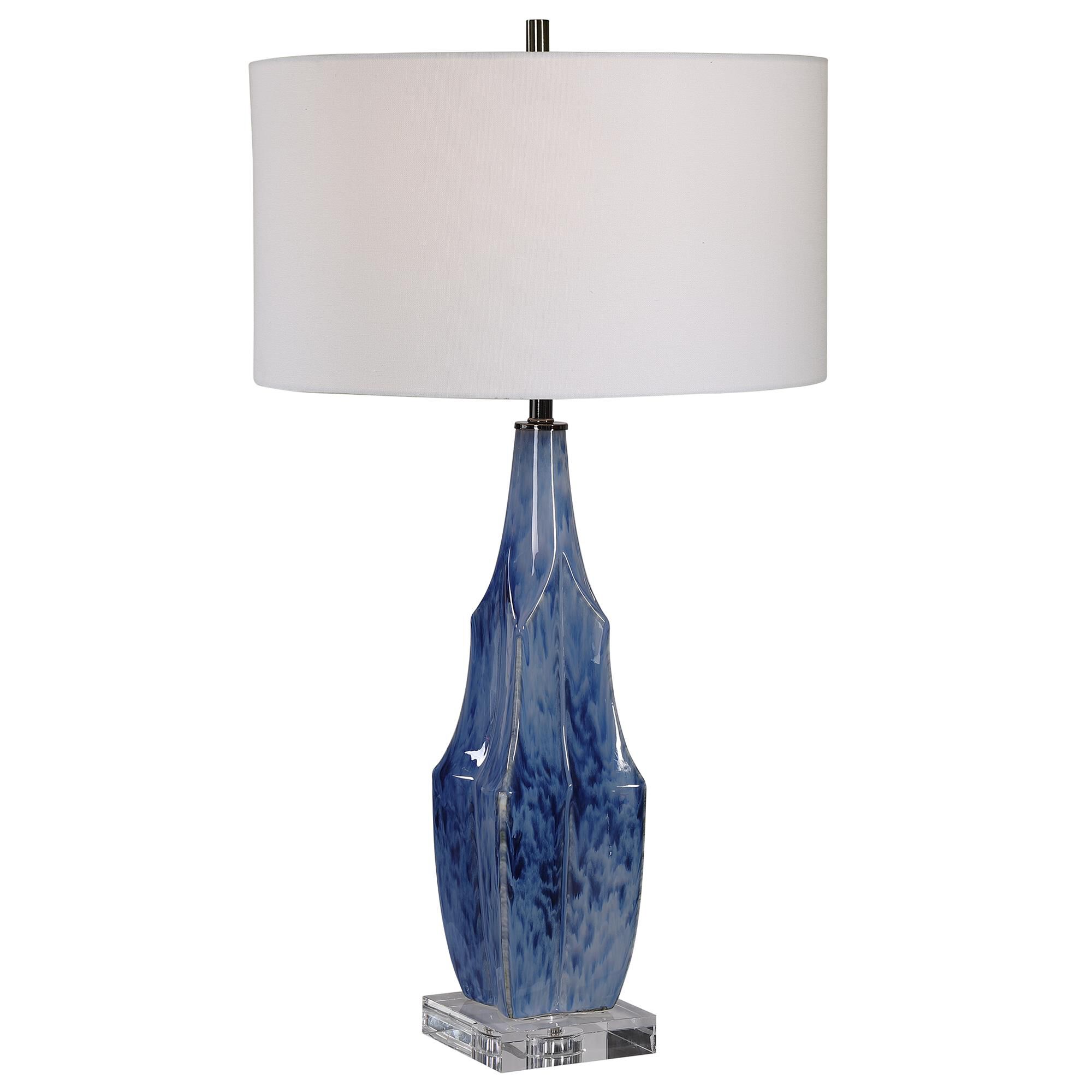 Shown in This Ceramic Table Lamp Is Finished In A Beautiful Reactive Indigo Blue Glaze, Accented By Elegant P finish and Round Drum shade