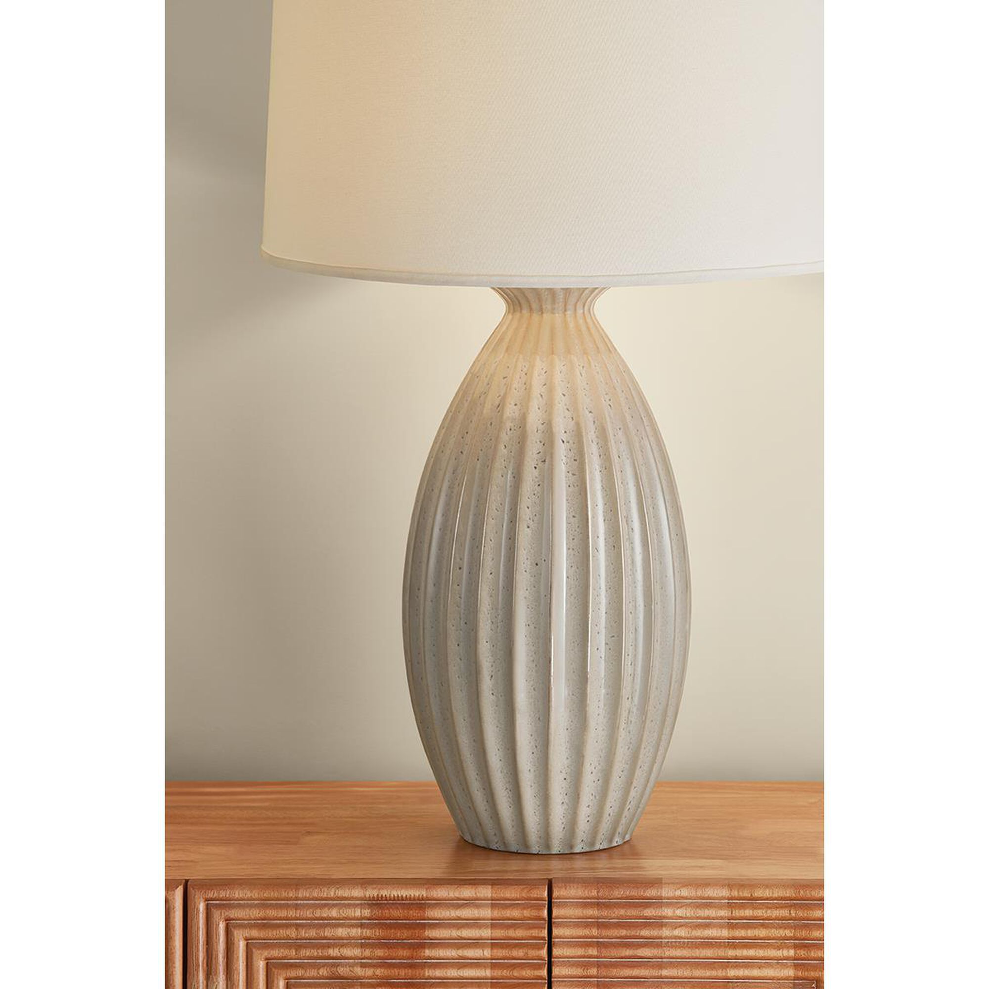 Shown in Aged Brass and Ceramic Taupe Velvet finish and White Linen shade
