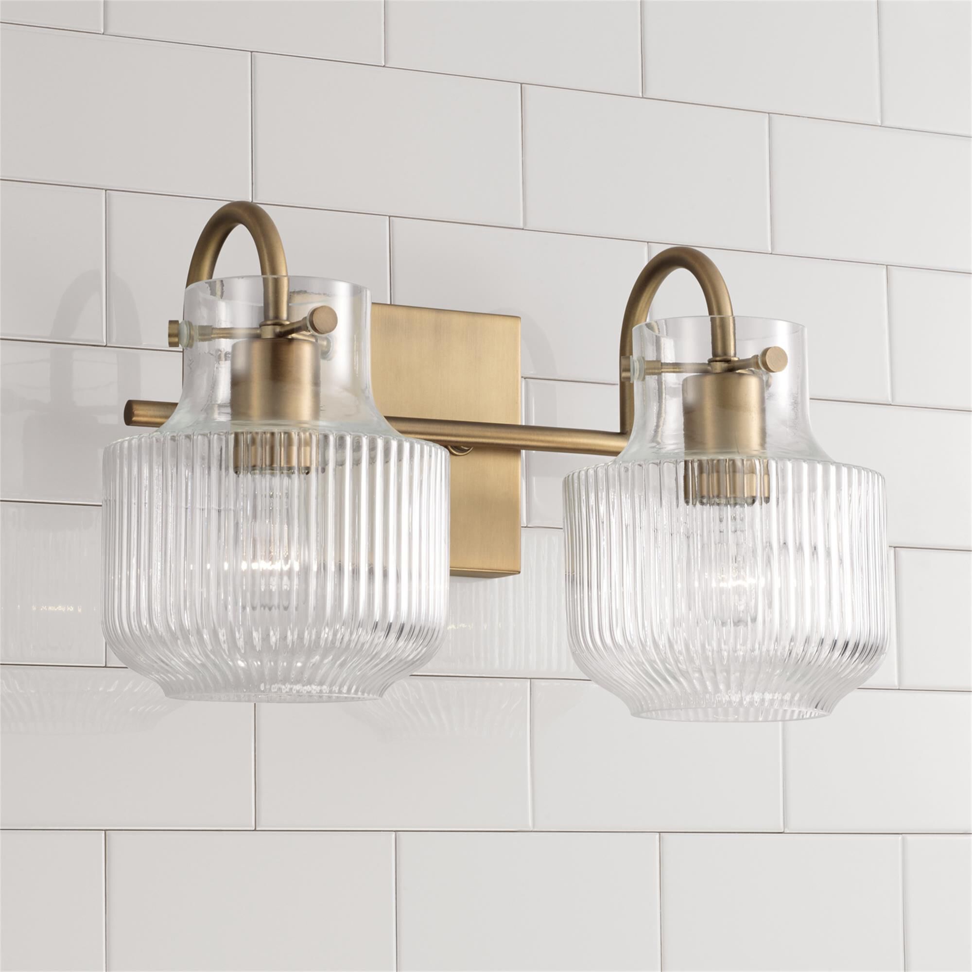 Shown in Aged Brass finish and Clear Fluted glass