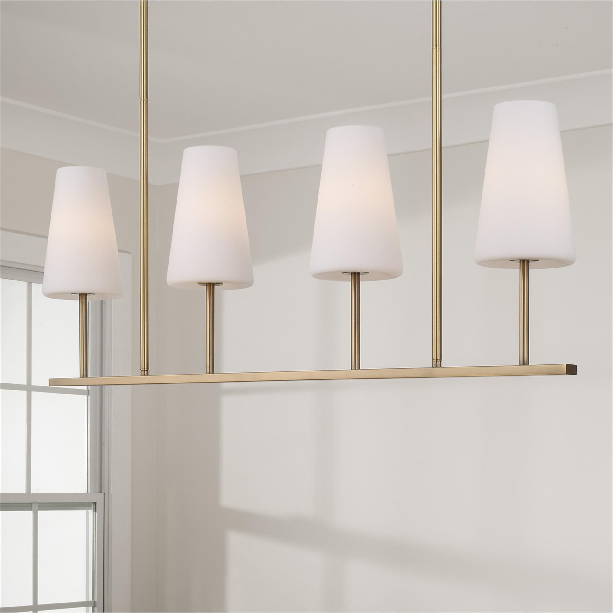 Shown in Aged Brass finish and Soft White glass