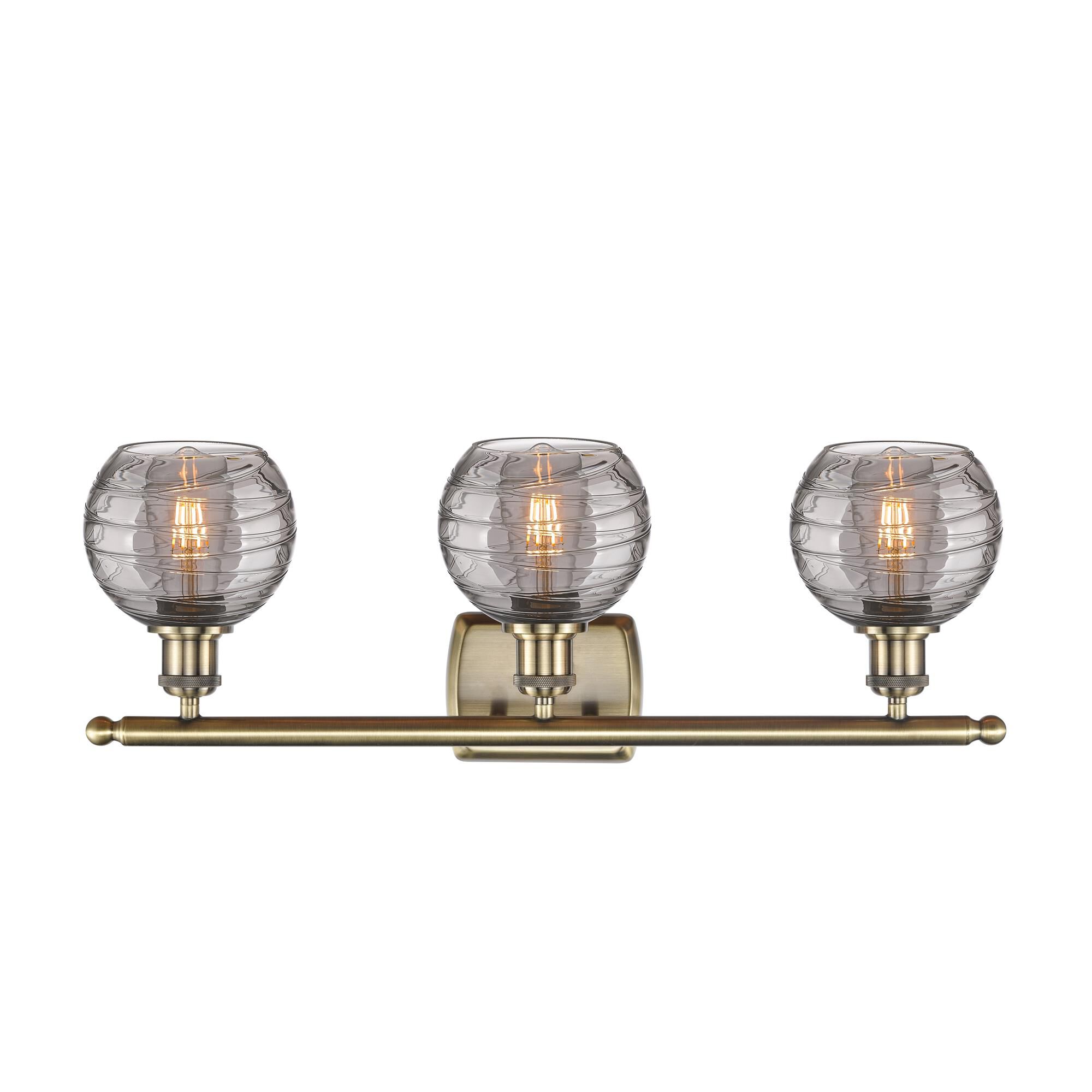 Shown in Antique Brass finish and Light Smoke Deco Swirl glass