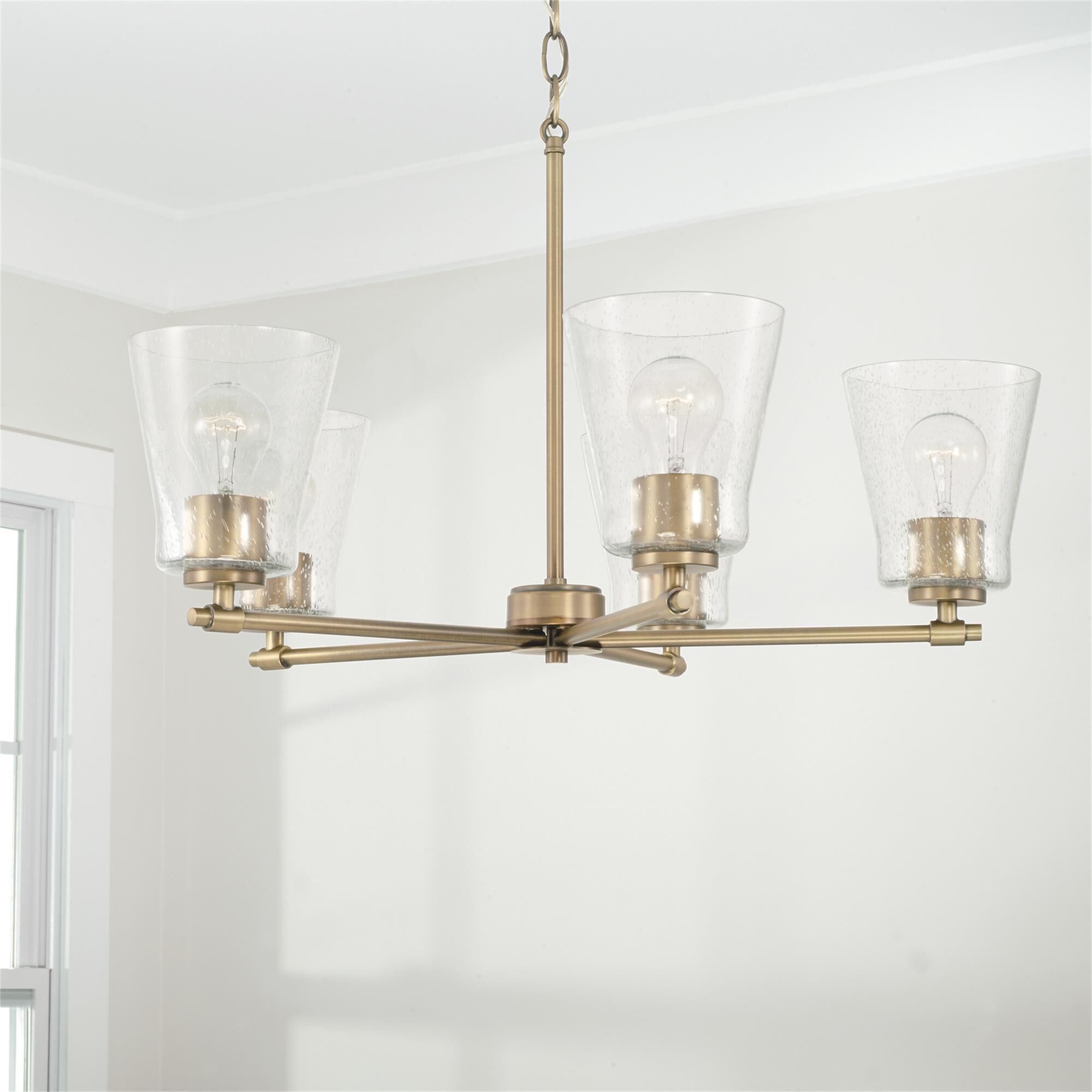 Shown in Aged Brass finish and Clear Seeded glass