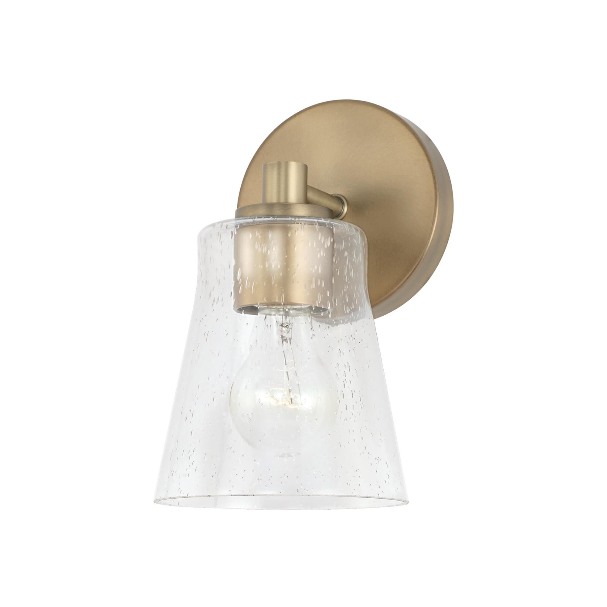 Shown in Aged Brass finish and Clear Seeded glass