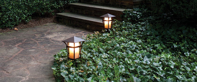 Lantern-style pathway lights from Capitol Lighting illuminate the home entrance.